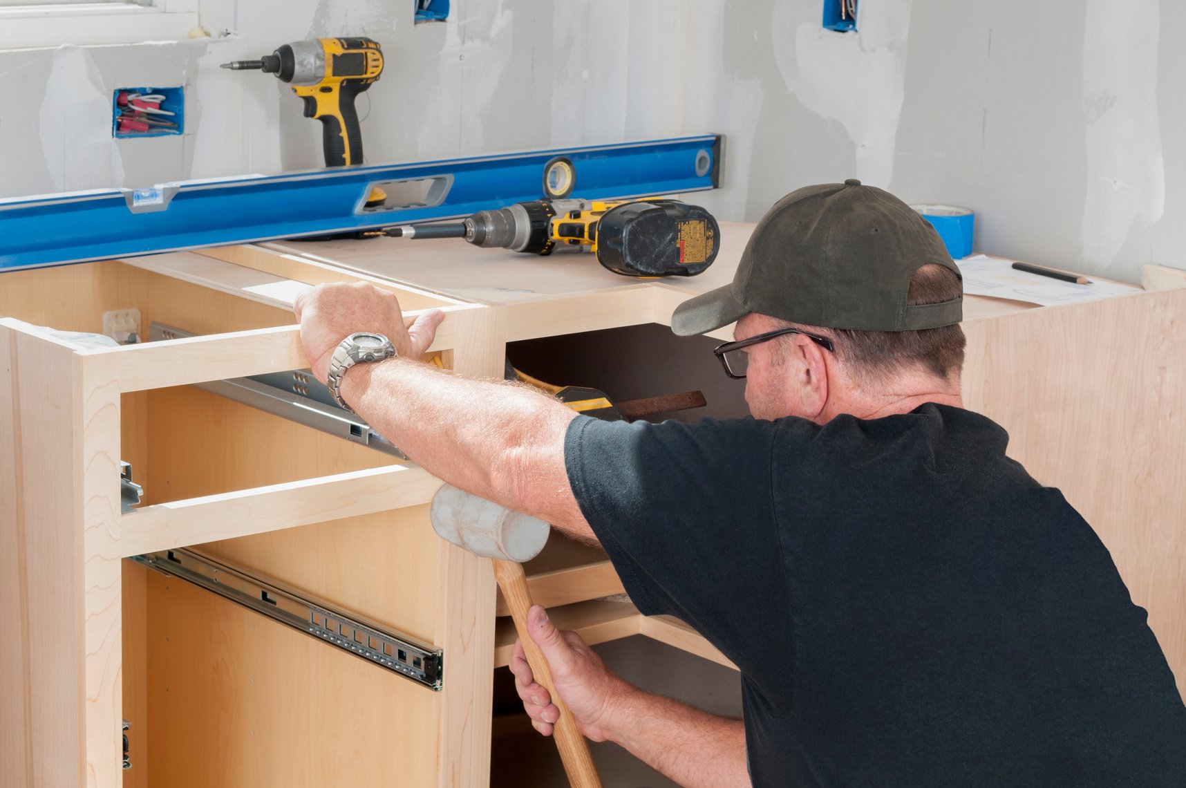 Construction Worker Installing Kitchen Cabinets